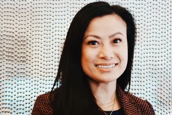 Headshot of a woman in a suit, smiling at the camera